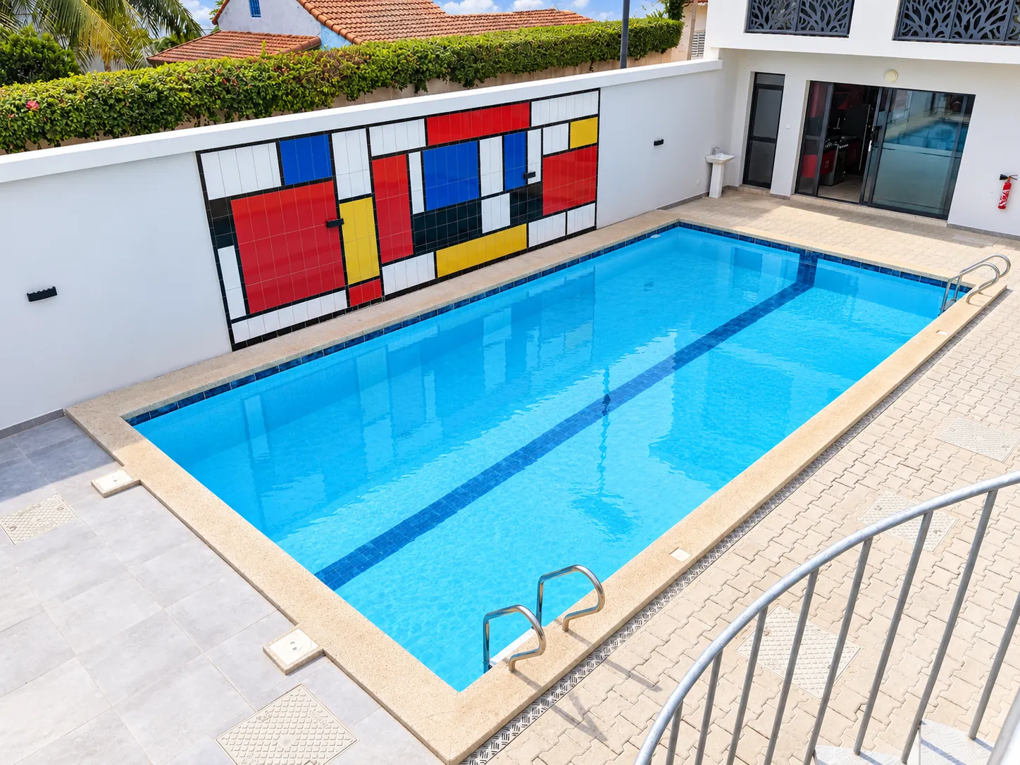 Piscine de la résidence Le Mondrian et son mur orné d'une composition géométrique aux couleurs primaires.